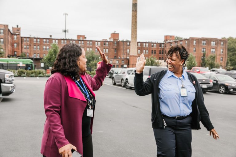 two female employees give a high five