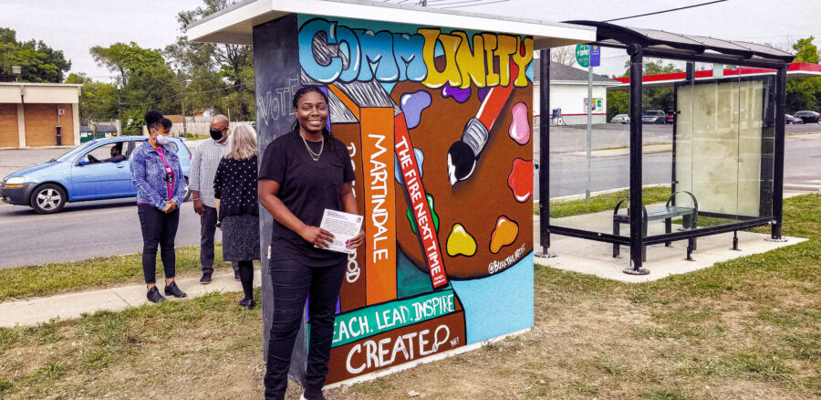artist poses in front of created in front of wall
