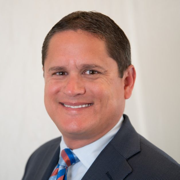 A smiling man in a suit and tie.