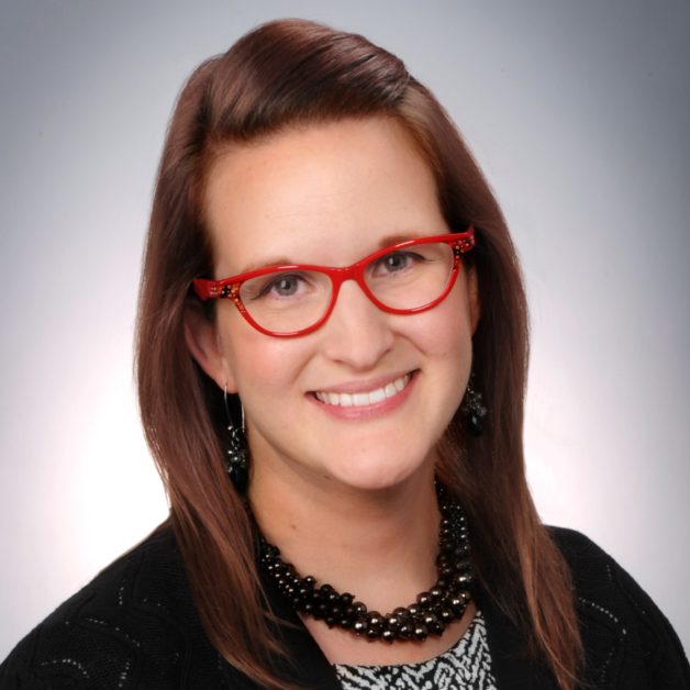 A stylish woman wearing red glasses and a black blouse.