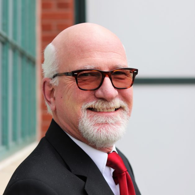 An man with a white beard, looking wise and dignified.