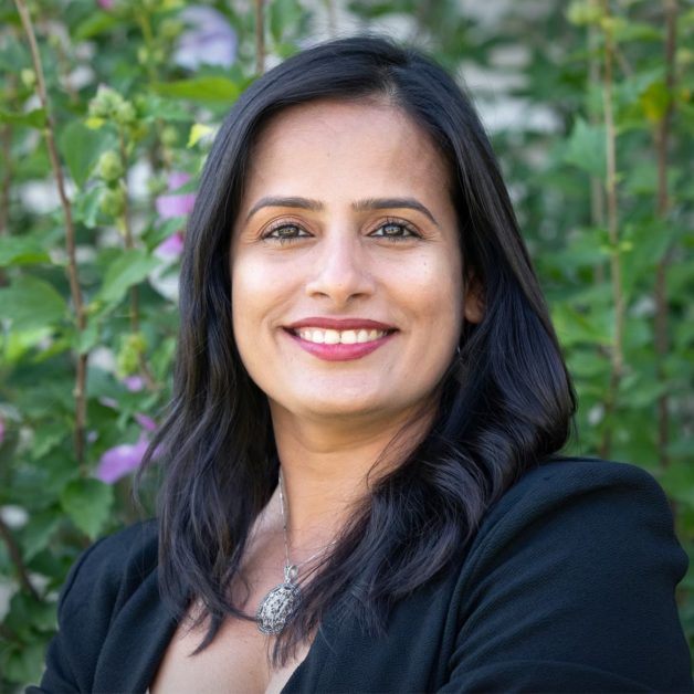 A professional woman with long black hair wearing a black blazer.