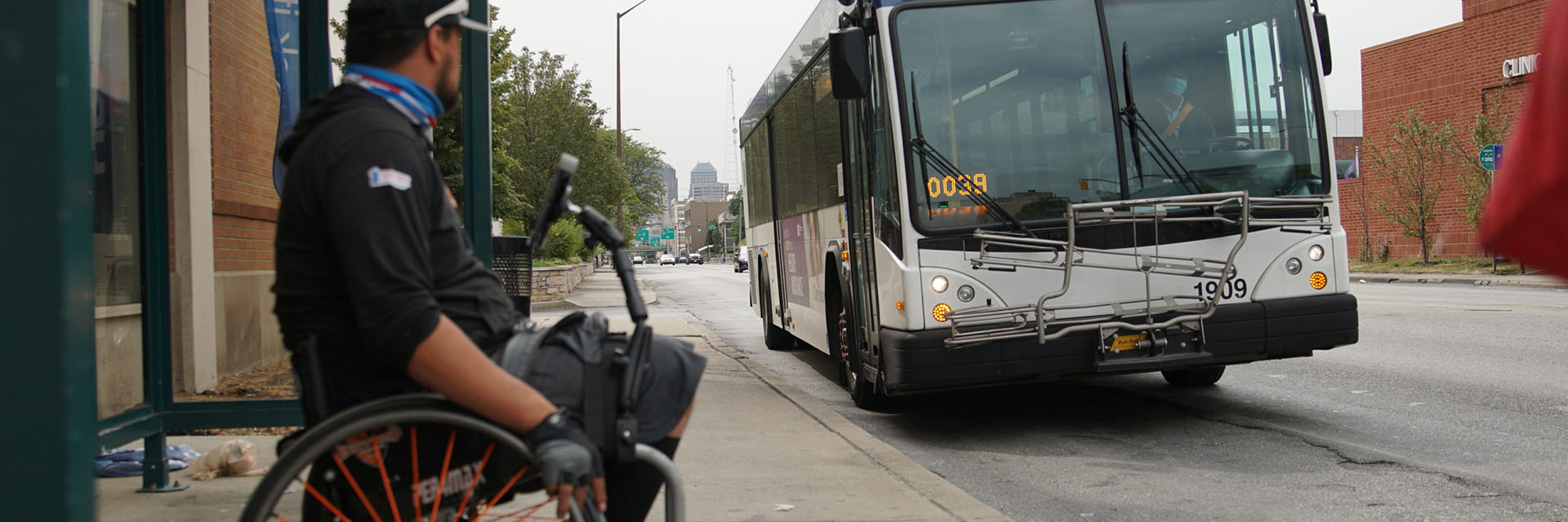 man in wheelchair waiting on bus