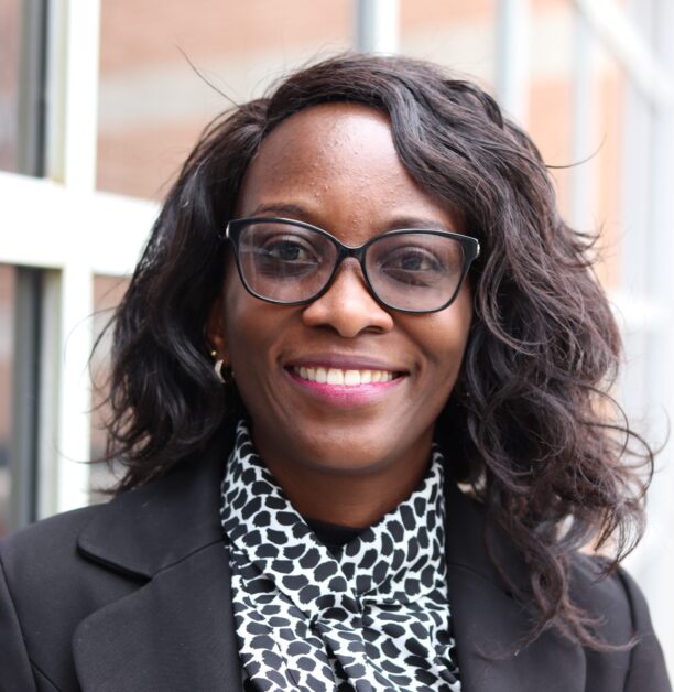 A professional woman wearing glasses and a blazer, exuding confidence and intelligence.