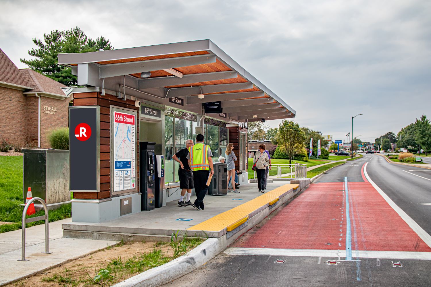 Group of people standing at the Red Line bus stop.