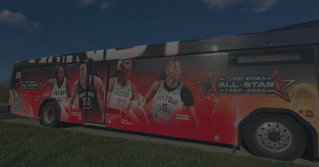 Side shot of an IndyGo bus with a WNBA wrap.