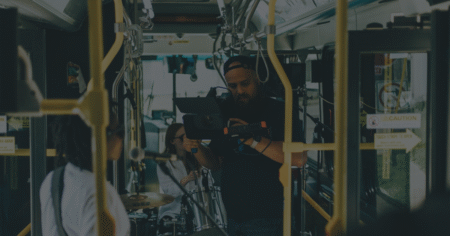 Man filming performer during music in transit.